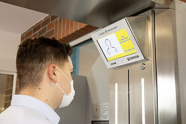 Sobald eine Person vor den Hygiene-Checkpoint "Liward" von CWS und Emdion tritt, messen Sensoren berührungslos die Temperatur im Gesicht.